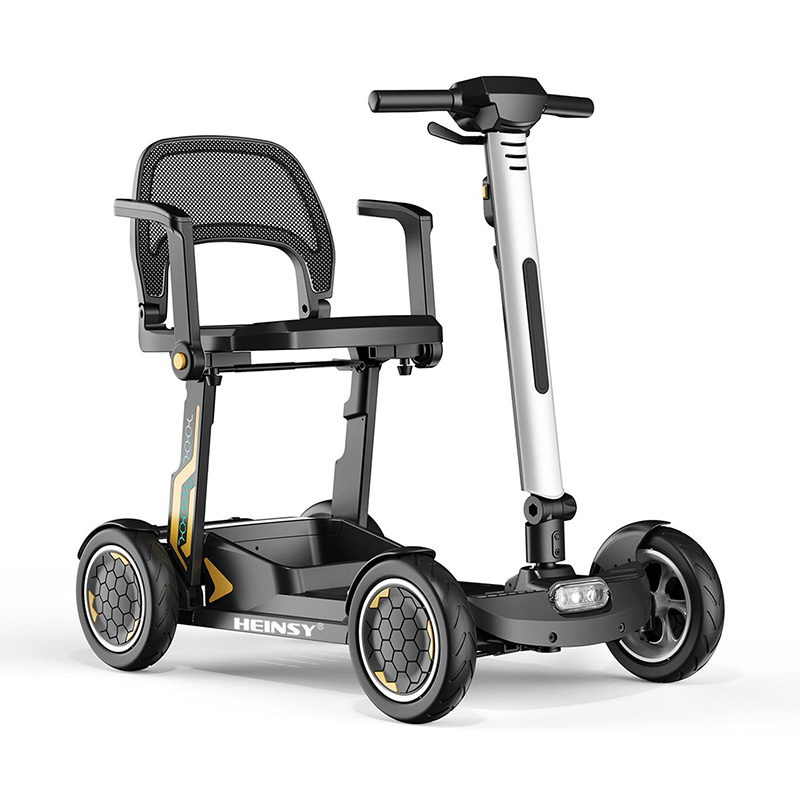 portable travel mobility scooter folded next to a car trunk